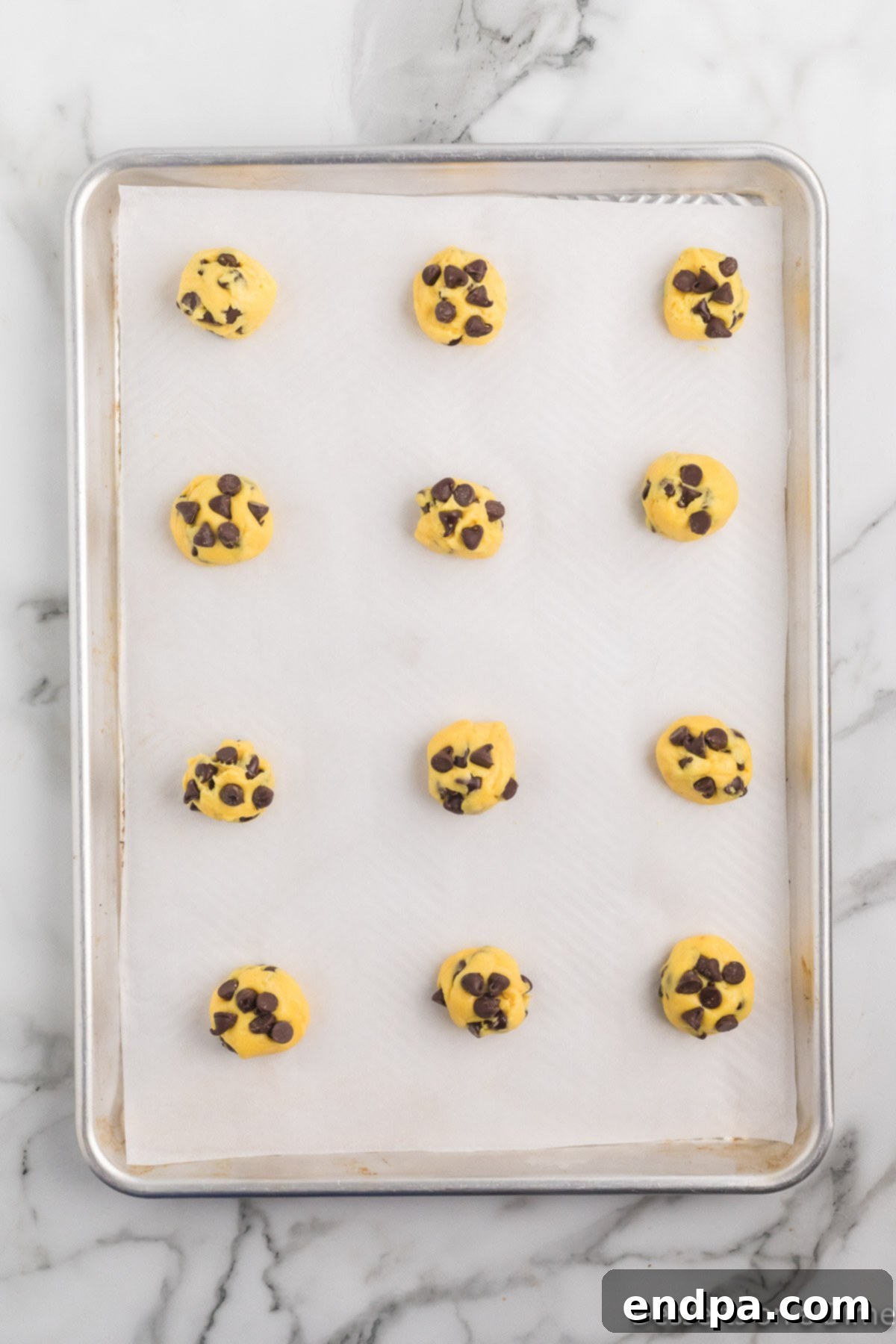 Irresistible Chocolate Chip Cake Mix Cookies 6 Scoops of cake mix cookie dough arranged on a baking sheet, ready for the oven.