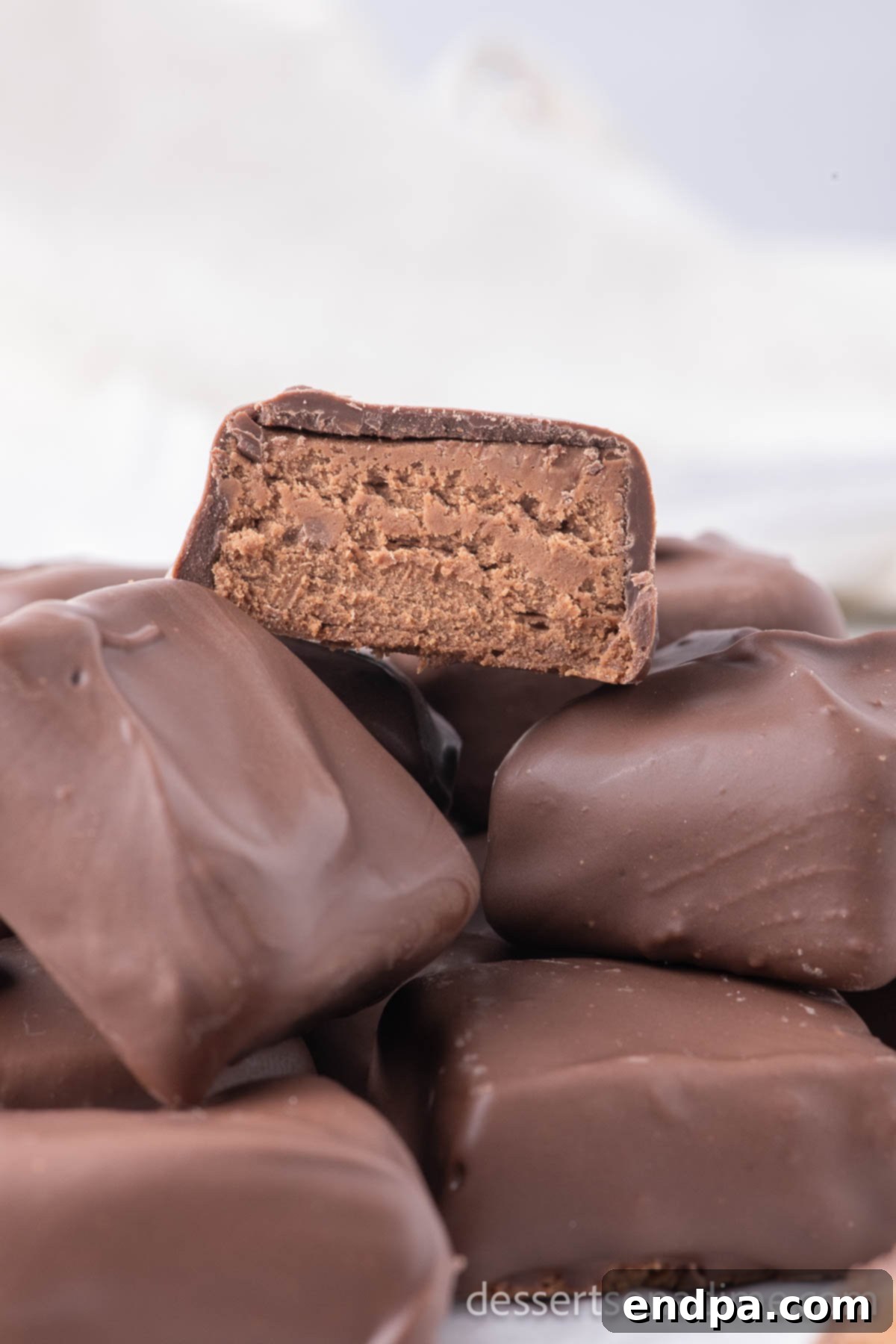 Cool Whip candy stacked together, showing its fluffy interior and chocolate coating.