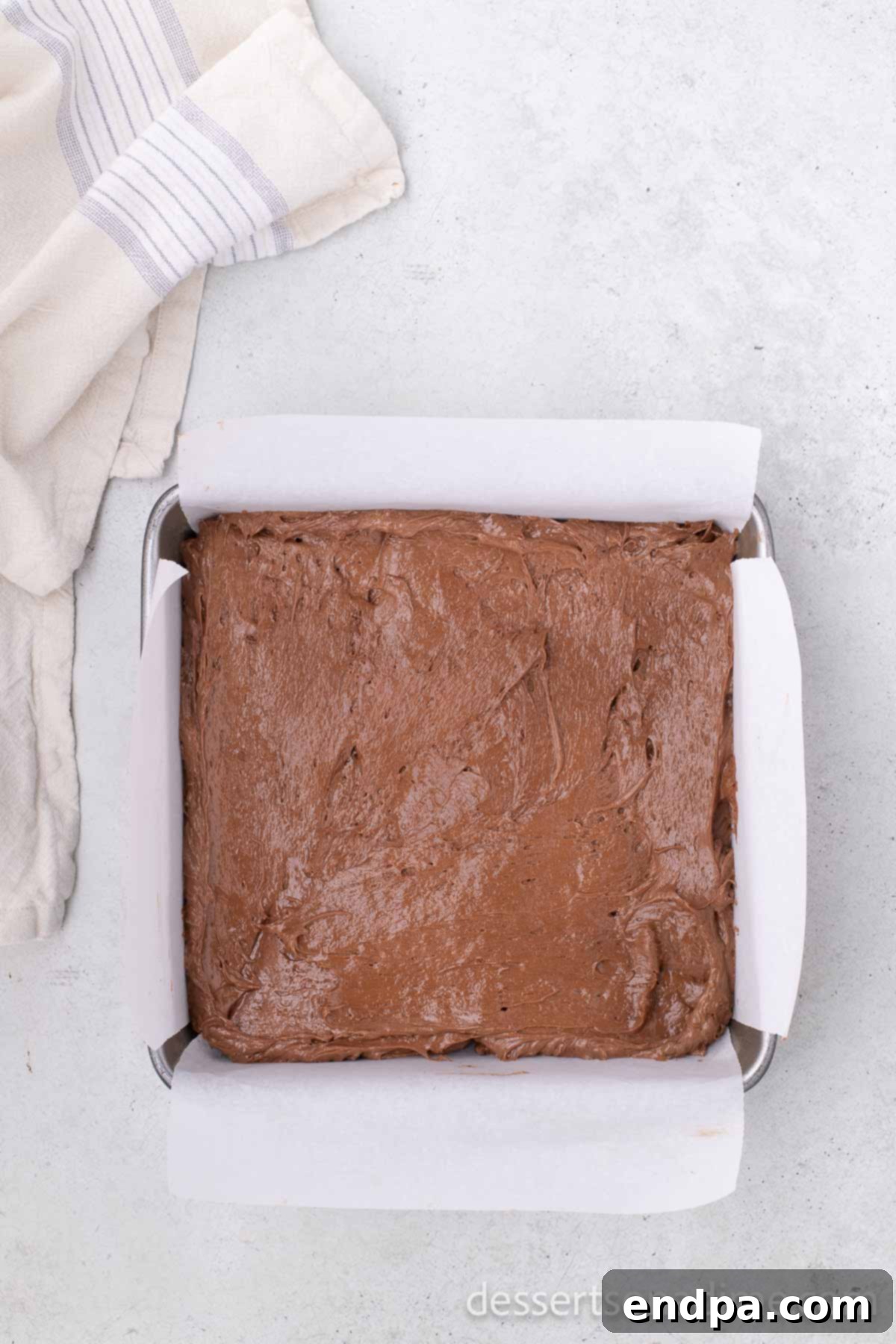 Chocolate mixture spread evenly in a pan, ready for freezing.
