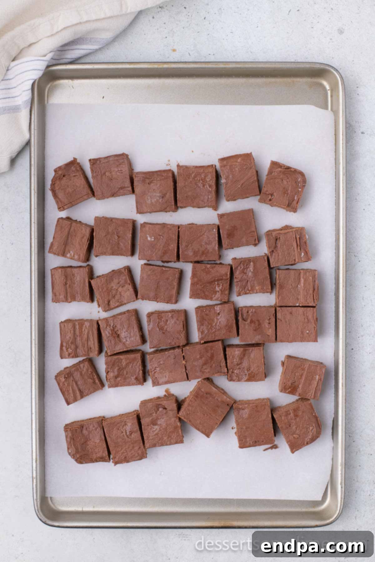 Cut chocolate squares arranged on a baking sheet lined with wax paper.