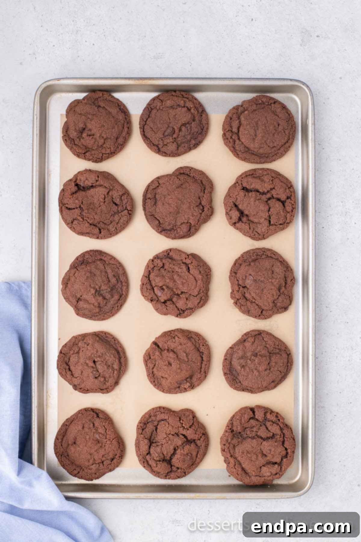 Freshly baked Nutella cookies on a baking sheet, showing their slightly golden edges and set tops, indicating they are perfectly done.