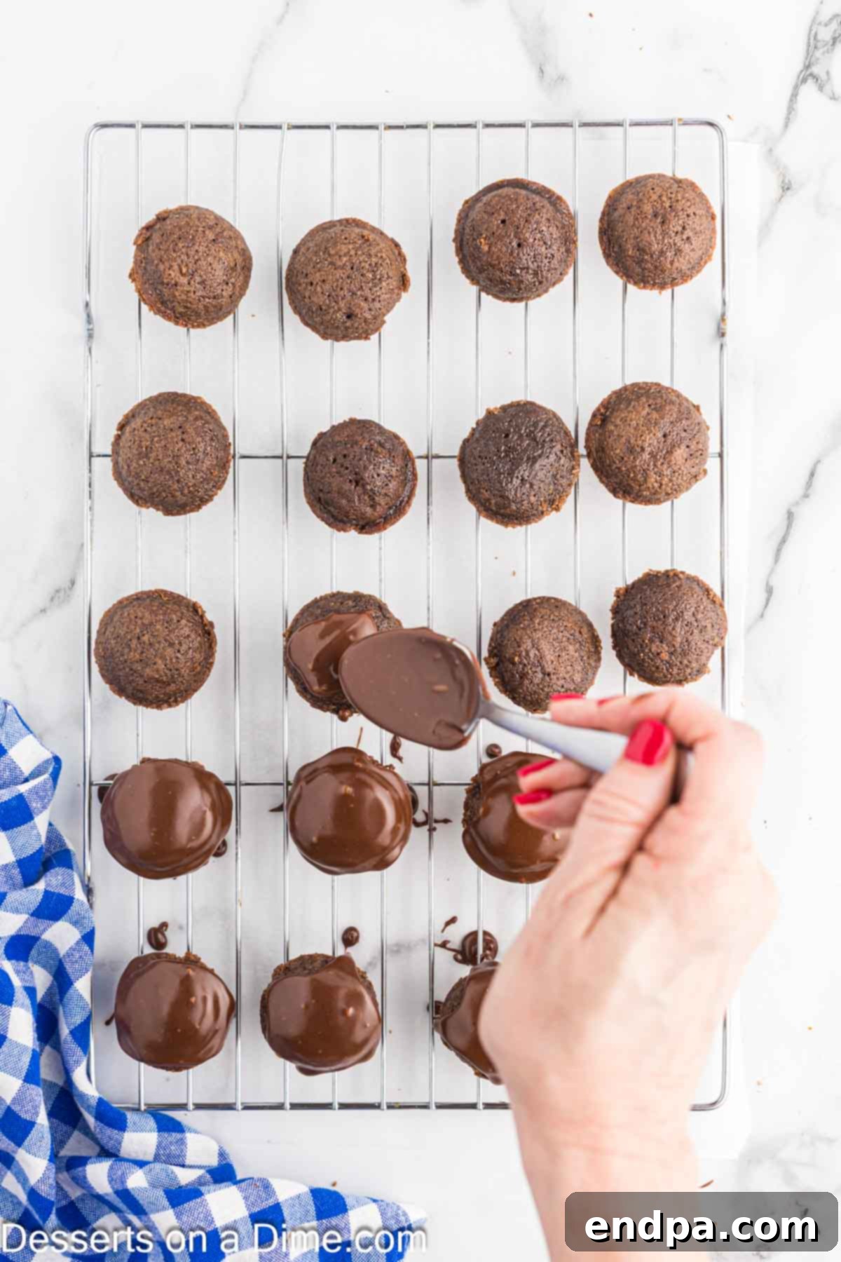 Texas Sheet Cake Minis 10 Rich chocolate frosting being spooned over individual Texas Sheet Cake Bites arranged on a wire rack.