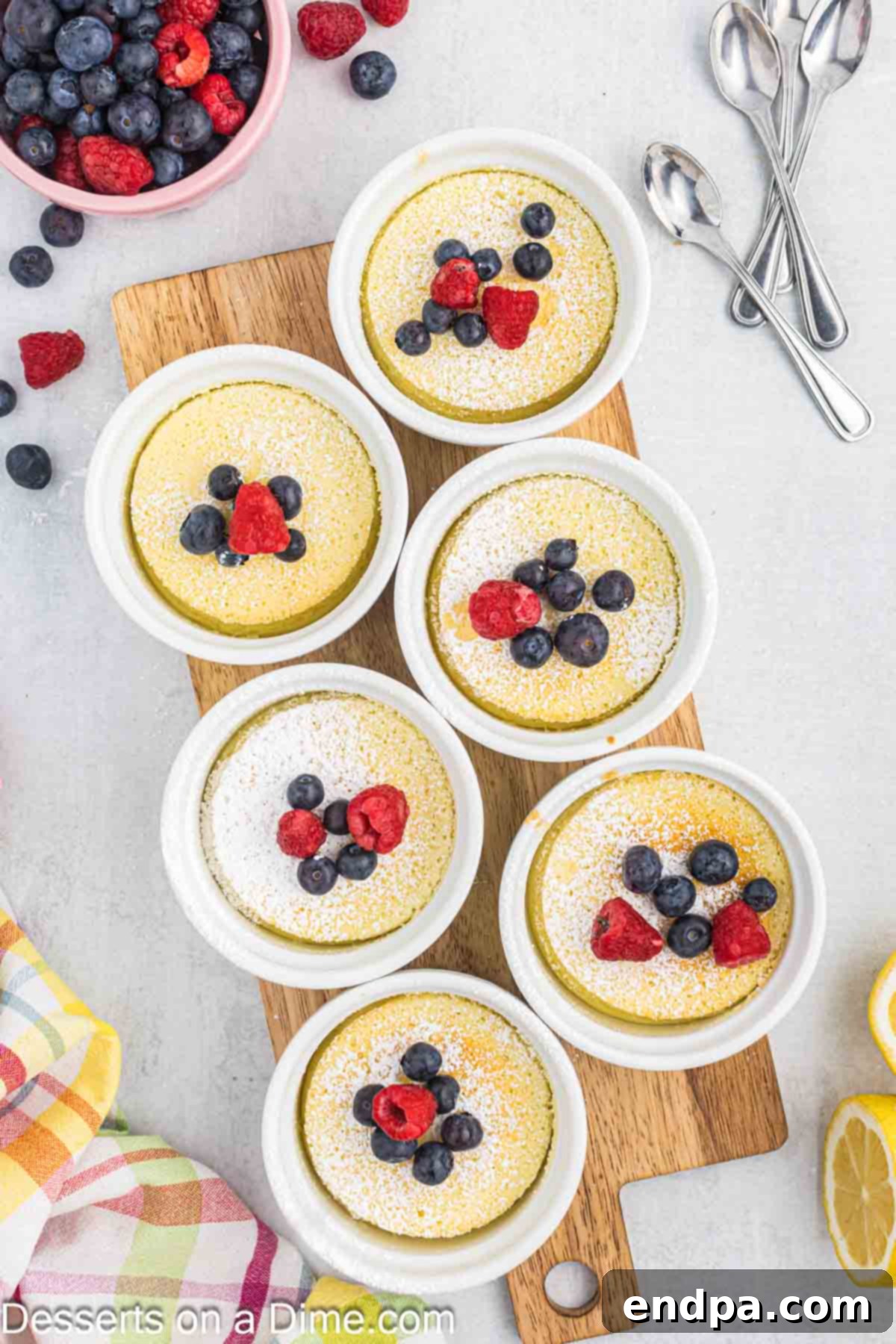 Lemon pudding cake topped with fresh berries and a sprig of mint.