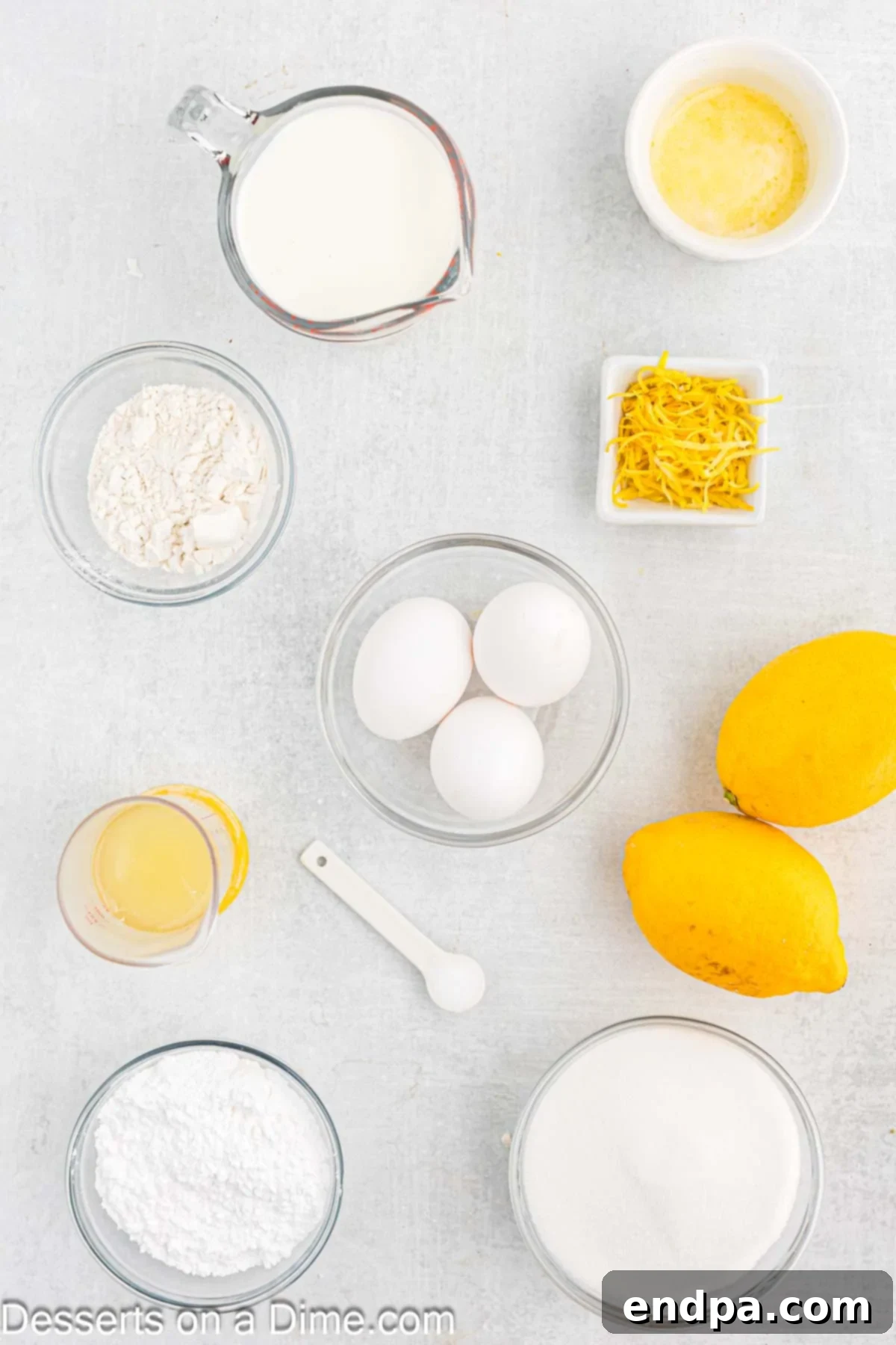 Collection of fresh ingredients for lemon pudding cake: butter, eggs, flour, milk, lemons, and sugar.