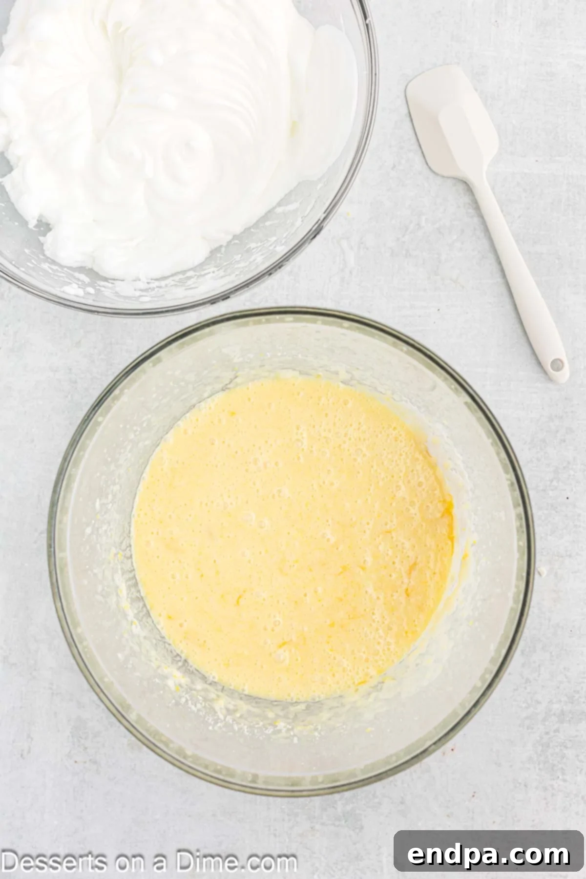 Mixing in milk, flour, fresh lemon juice, and lemon zest into the batter.