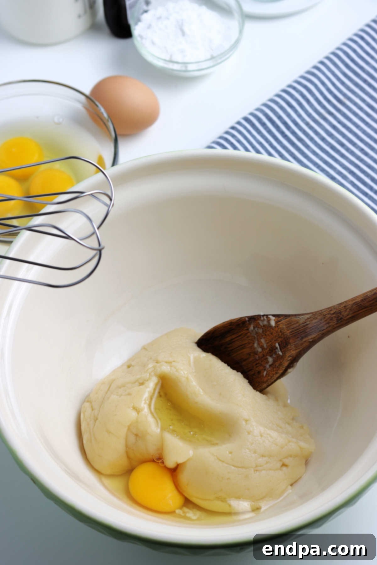 Irresistible Cream Puffs 2 Dough in bowl with eggs mixed in, showing the smooth, glossy consistency needed for piping.