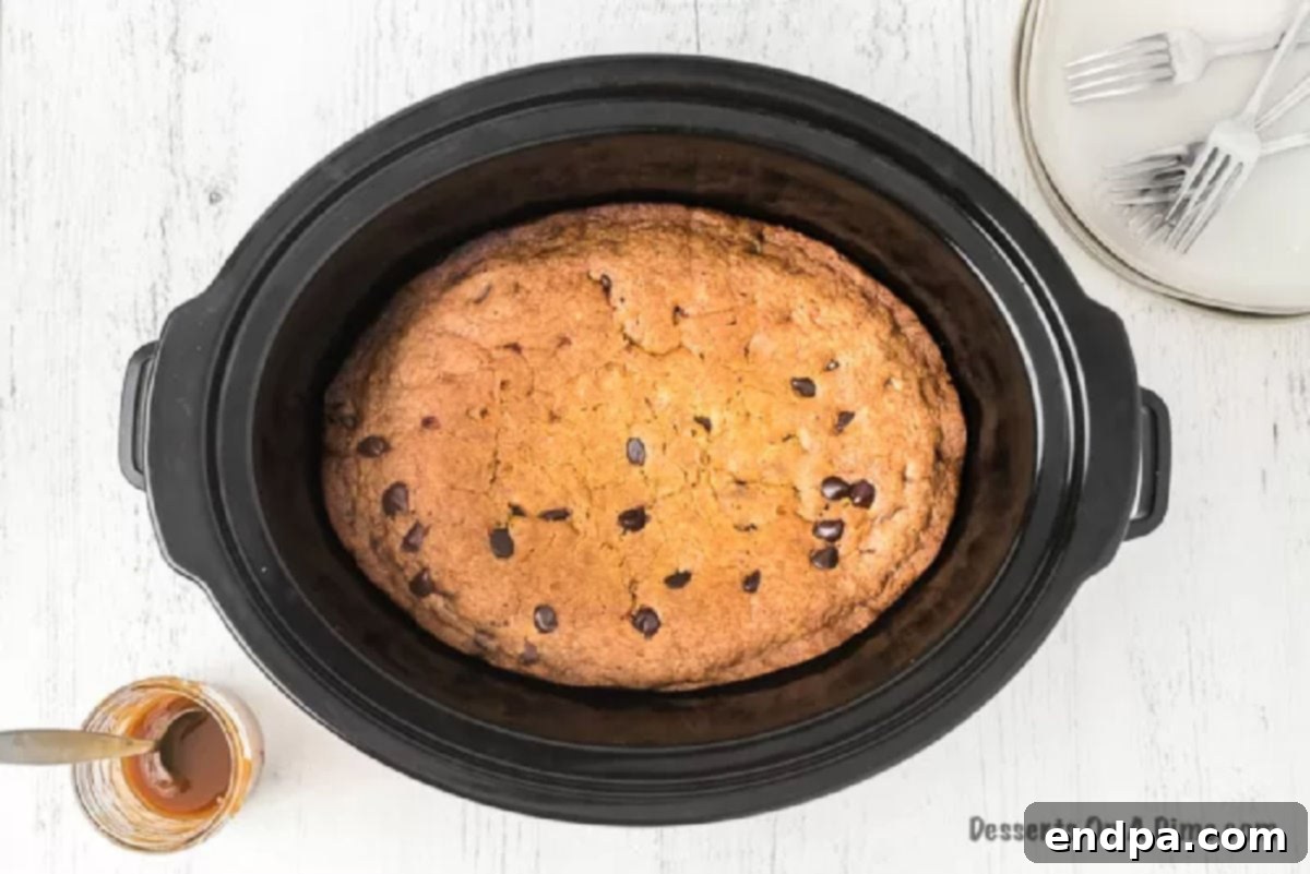 The slow cooker lid in place, with the cookie cake cooking on high.