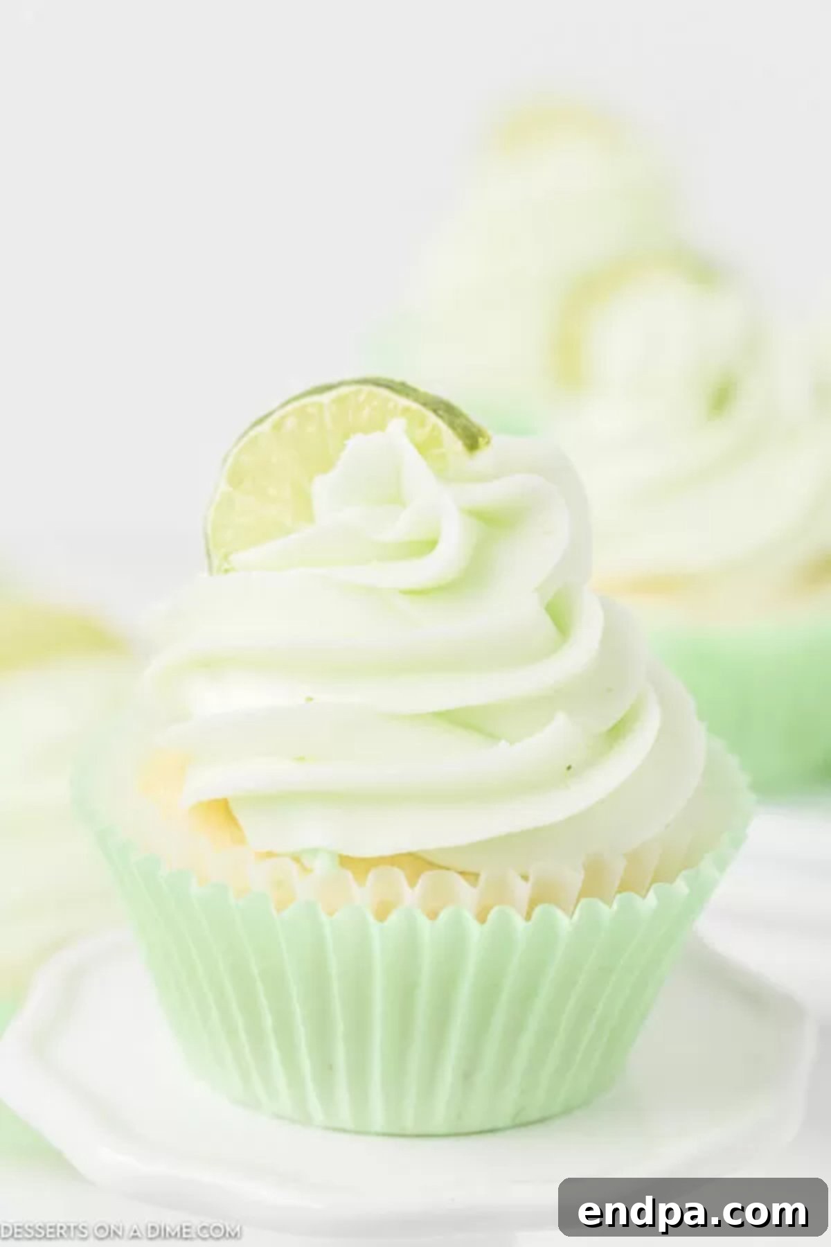 Key Lime Cupcakes, beautifully frosted with a swirl of buttercream and garnished with fresh lime slices, ready to be served.