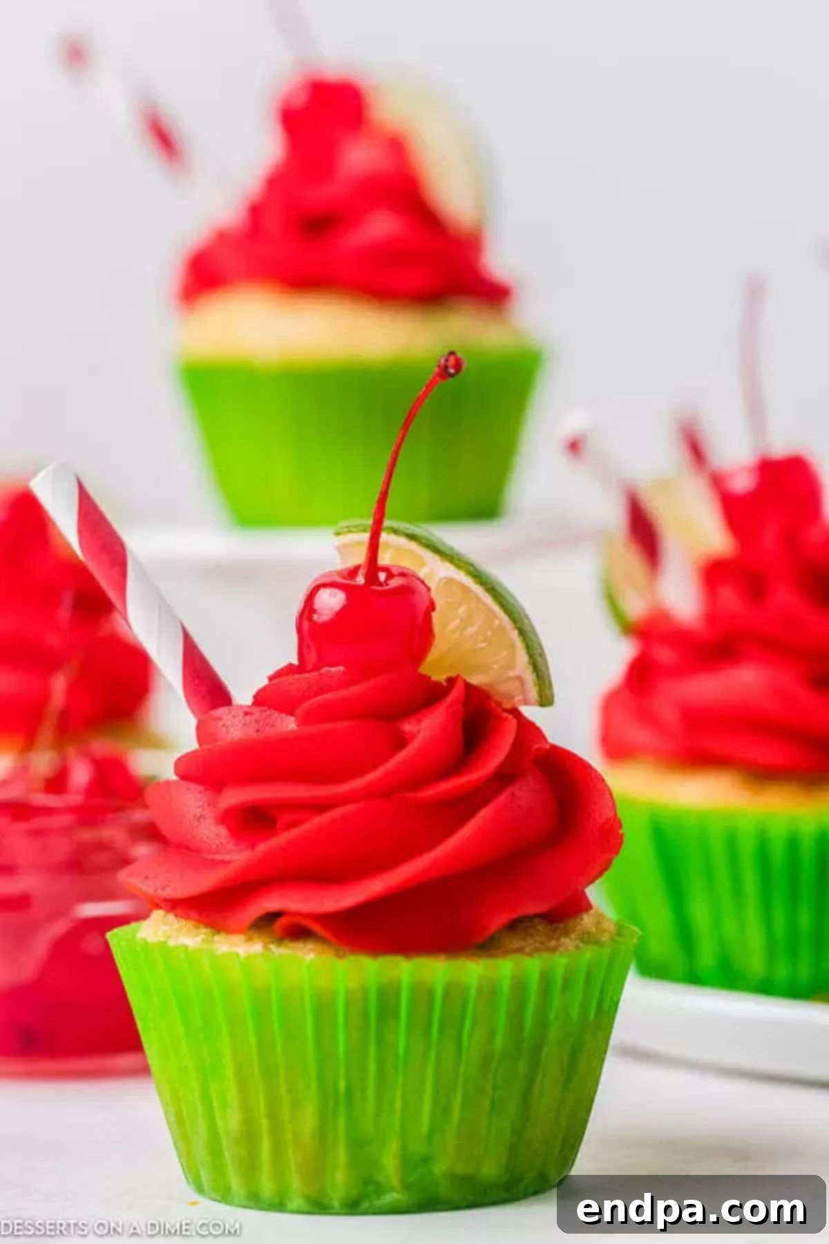 Cherry Limeade Cupcakes: The ultimate blend of tangy lime and sweet cherry in a perfectly moist cake with decadent frosting, ideal for any celebration. Vibrant Cherry Limeade Cupcake with a slice of fresh lime and a maraschino cherry on top, sitting on a rustic wooden surface, perfect for a summer treat.