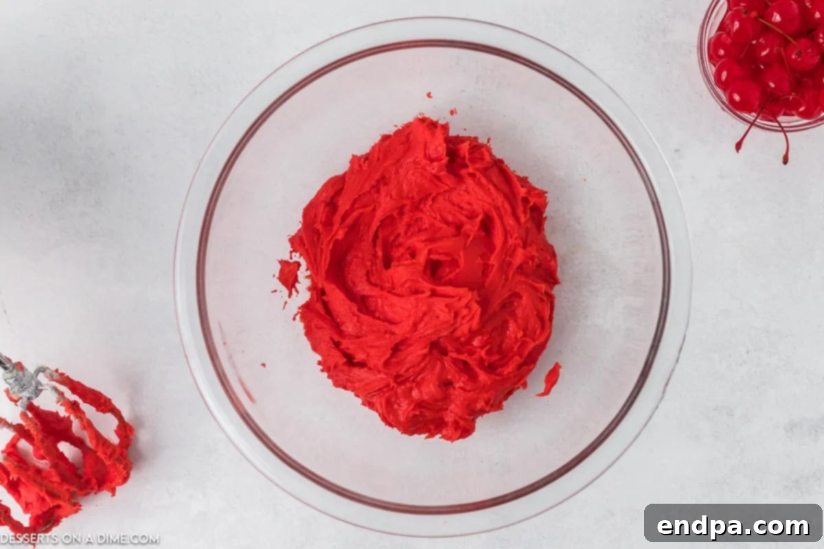Zingy Cherry Limeade Cupcakes 9 A spoonful of firm, brightly colored red cherry frosting, held upside down to demonstrate it holds its shape perfectly.