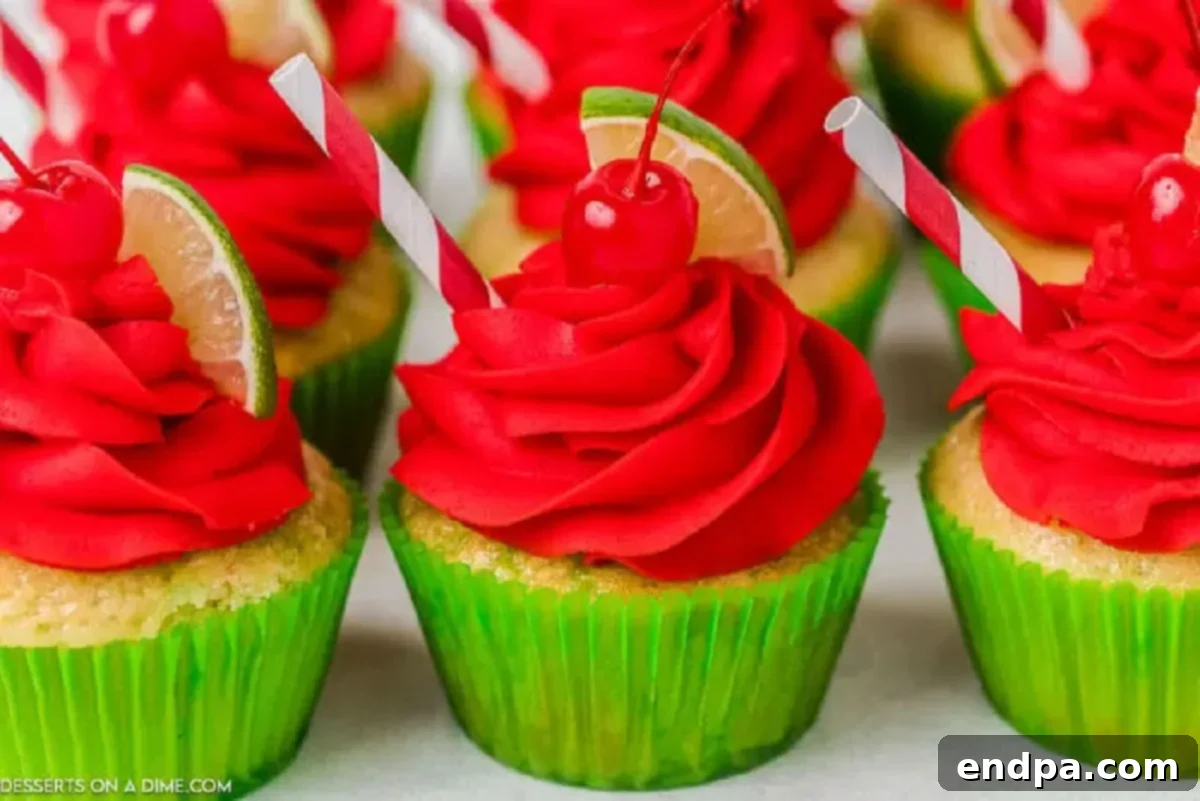 Zingy Cherry Limeade Cupcakes 11 Finished Cherry Limeade Cupcakes, beautifully frosted with bright red buttercream and elegantly garnished with small lime wedges and maraschino cherries on top.