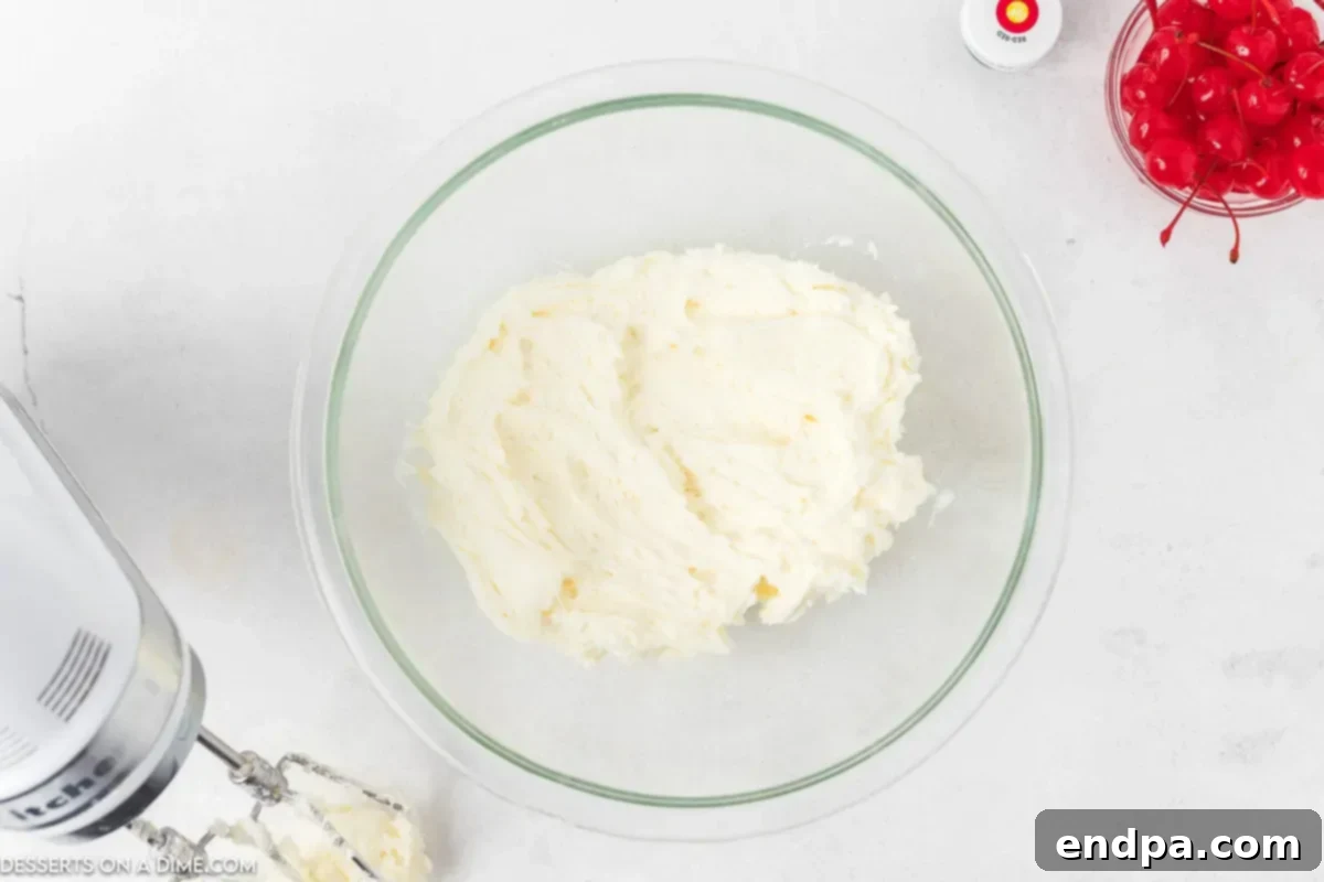 Zingy Cherry Limeade Cupcakes 7 A bowl of freshly prepared, creamy, white buttercream frosting, ready to be flavored and colored, in a stand mixer.