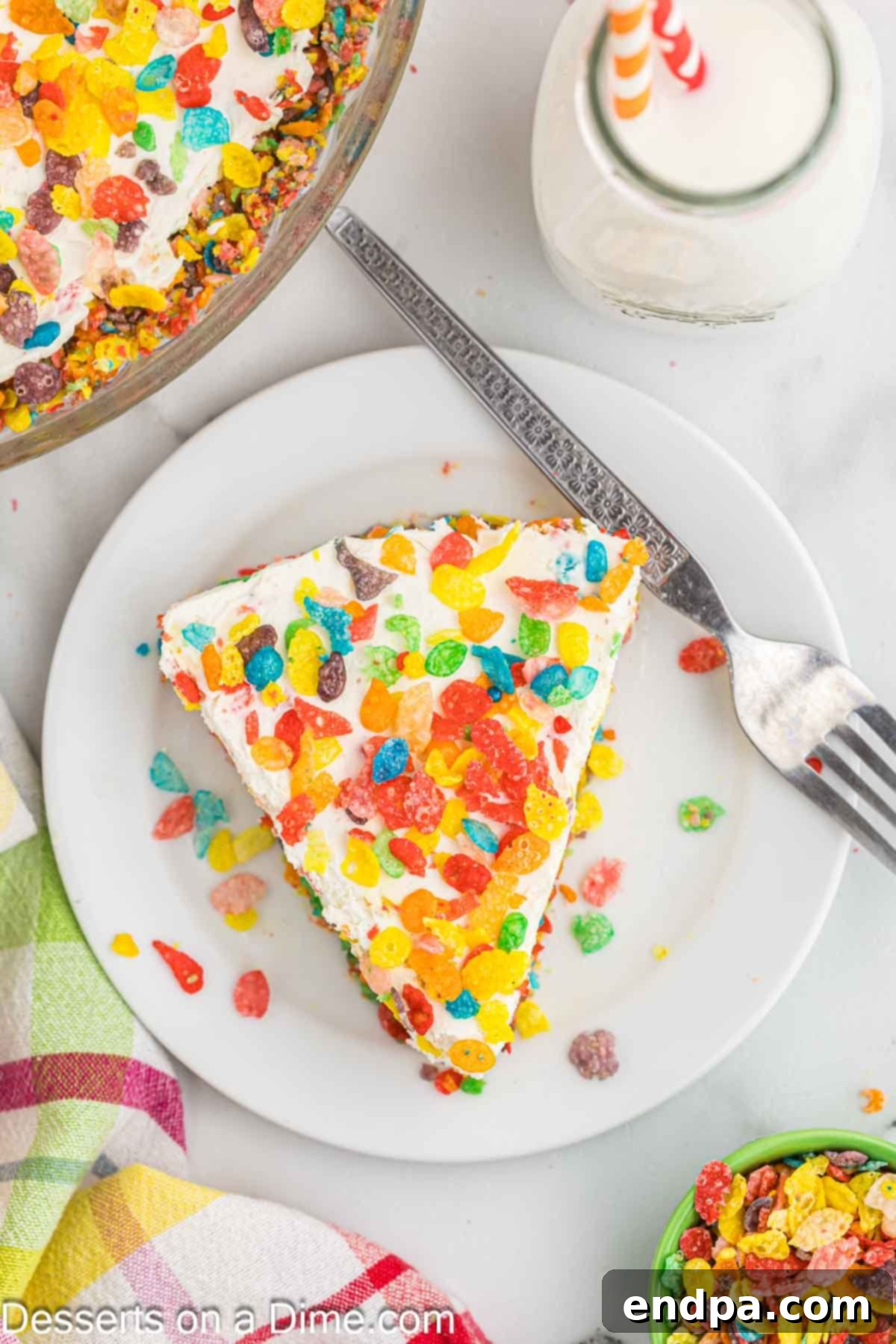Vibrant Fruity Pebbles Cheesecake 10 A perfectly portioned slice of Fruity Pebbles Cheesecake, garnished with extra cereal and possibly a drizzle of sauce, artfully presented on a plate.