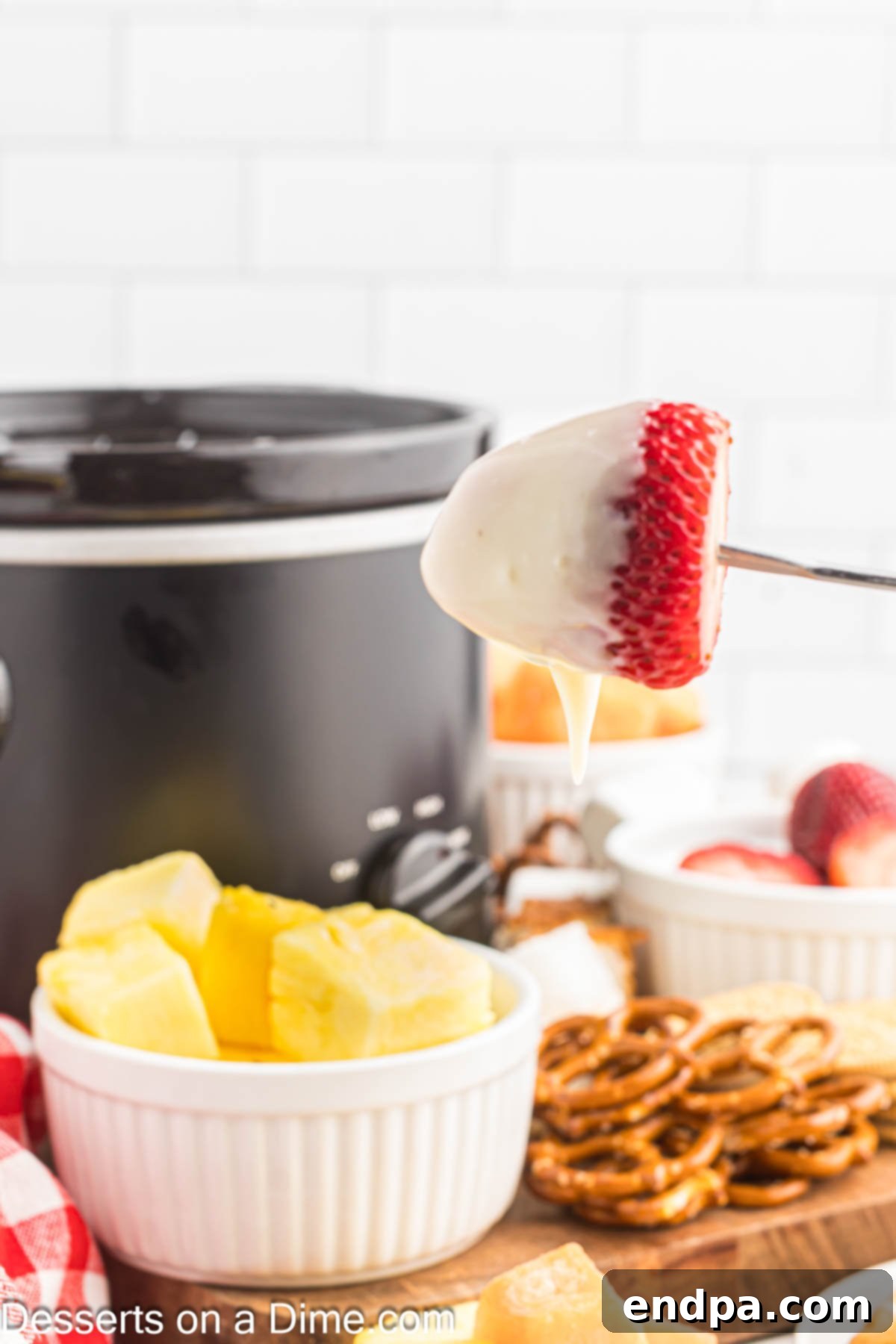 Decadent White Chocolate Fondue 2 A beautiful spread of white chocolate fondue with various fruits, ready to be dipped and enjoyed by guests.