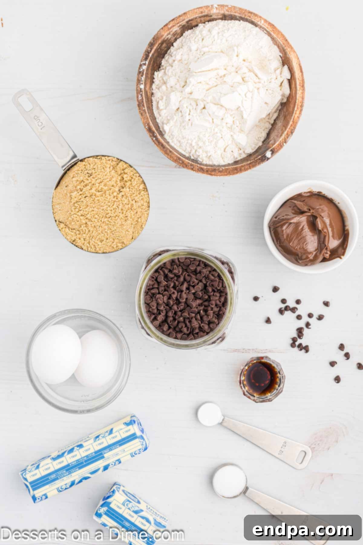 Decadent Nutella Bars 3 Ingredients for Nutella Bars laid out: butter, brown sugar, eggs, vanilla, flour, chocolate chips, Nutella.