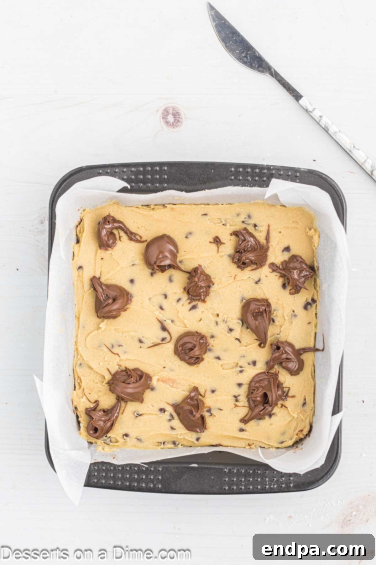 Decadent Nutella Bars 10 Remaining cookie dough dolloped on top, followed by spoonfuls of the second half of Nutella.