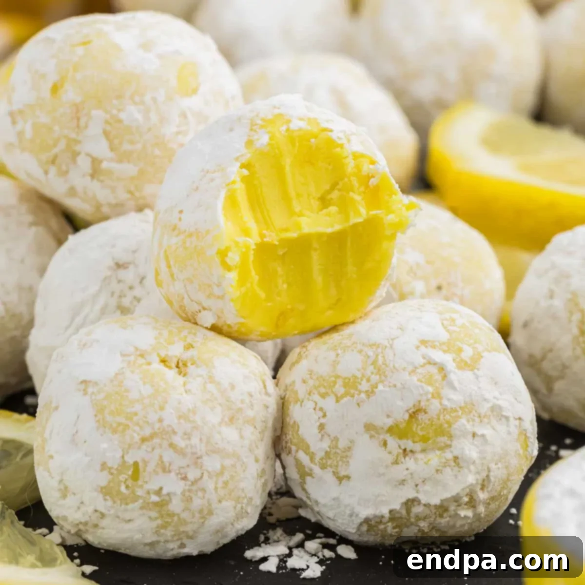 A close-up shot of several freshly made Lemon Truffles, coated in powdered sugar and ready to be served.