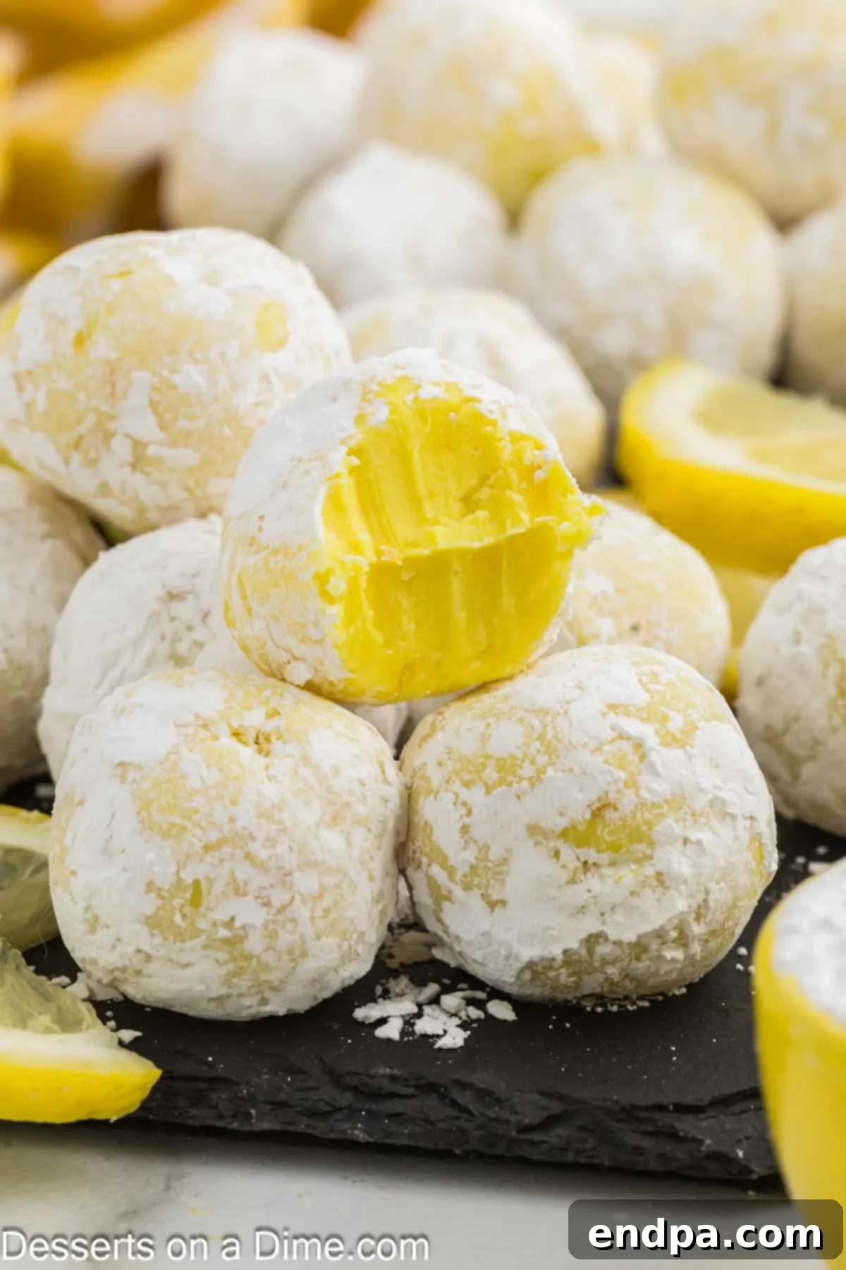 Lemon Truffles ready to serve on a white plate with lemon slices.