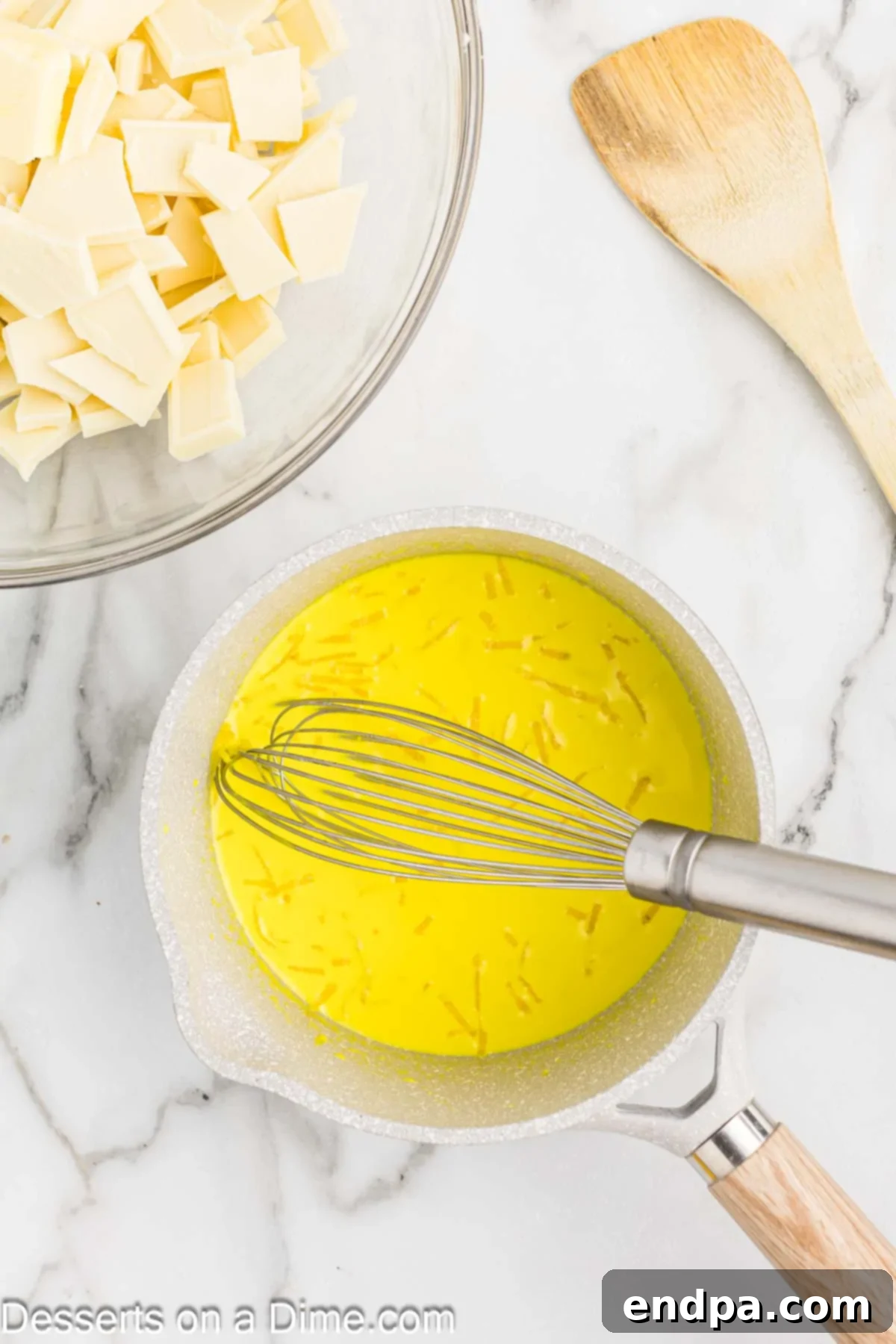 Saucepan with lemon extract and fresh lemon zest combined into the hot cream mixture.