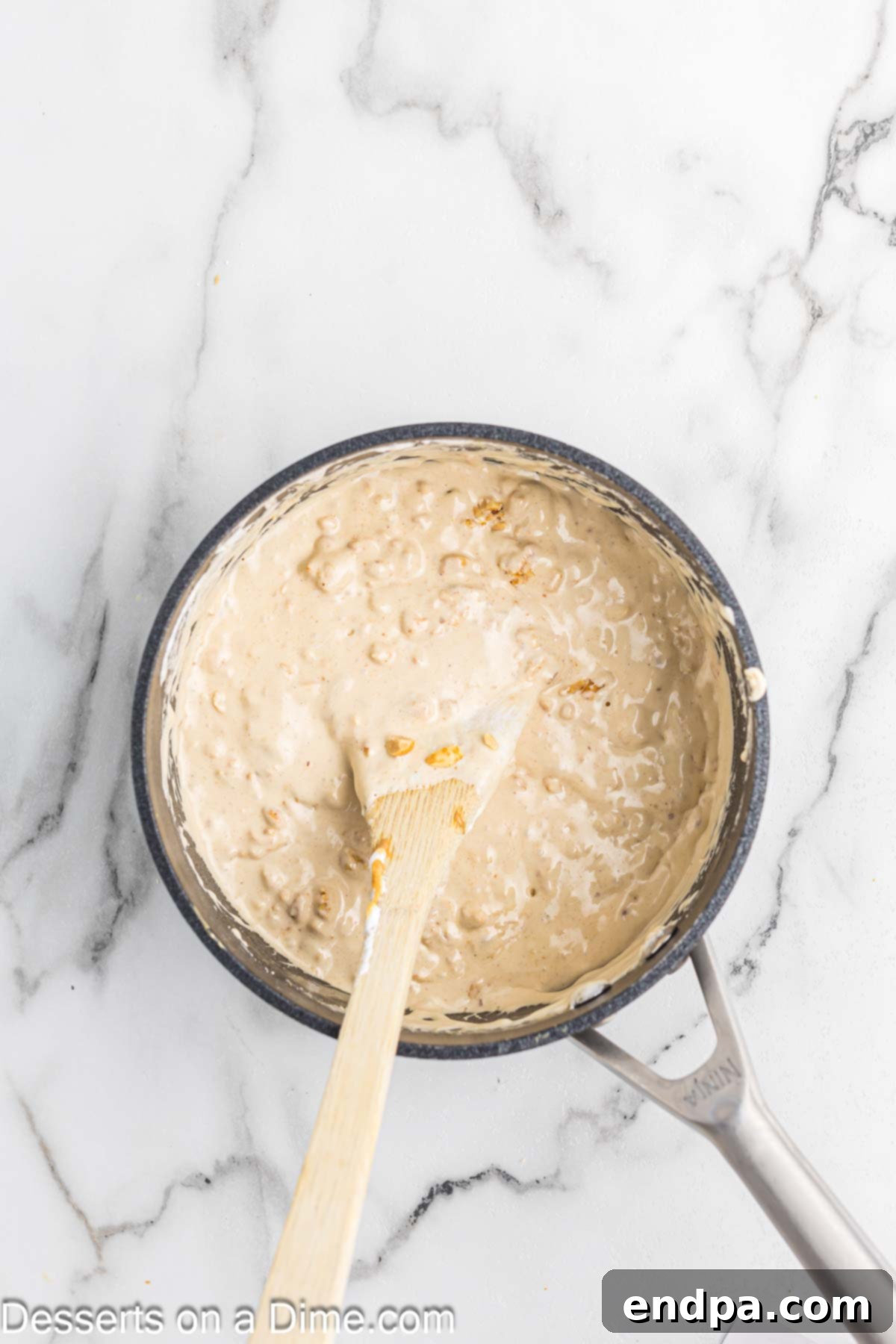 Peanuts added to nougat mixture in pan.