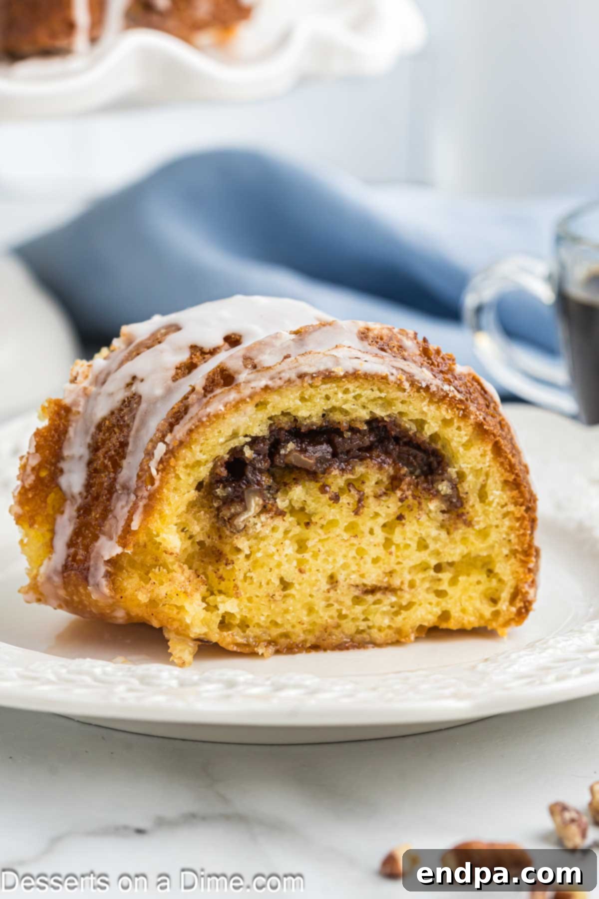 Slice of Sock it to me Bundt Cake on a plate. A perfect slice revealing the cinnamon streusel layer inside.
