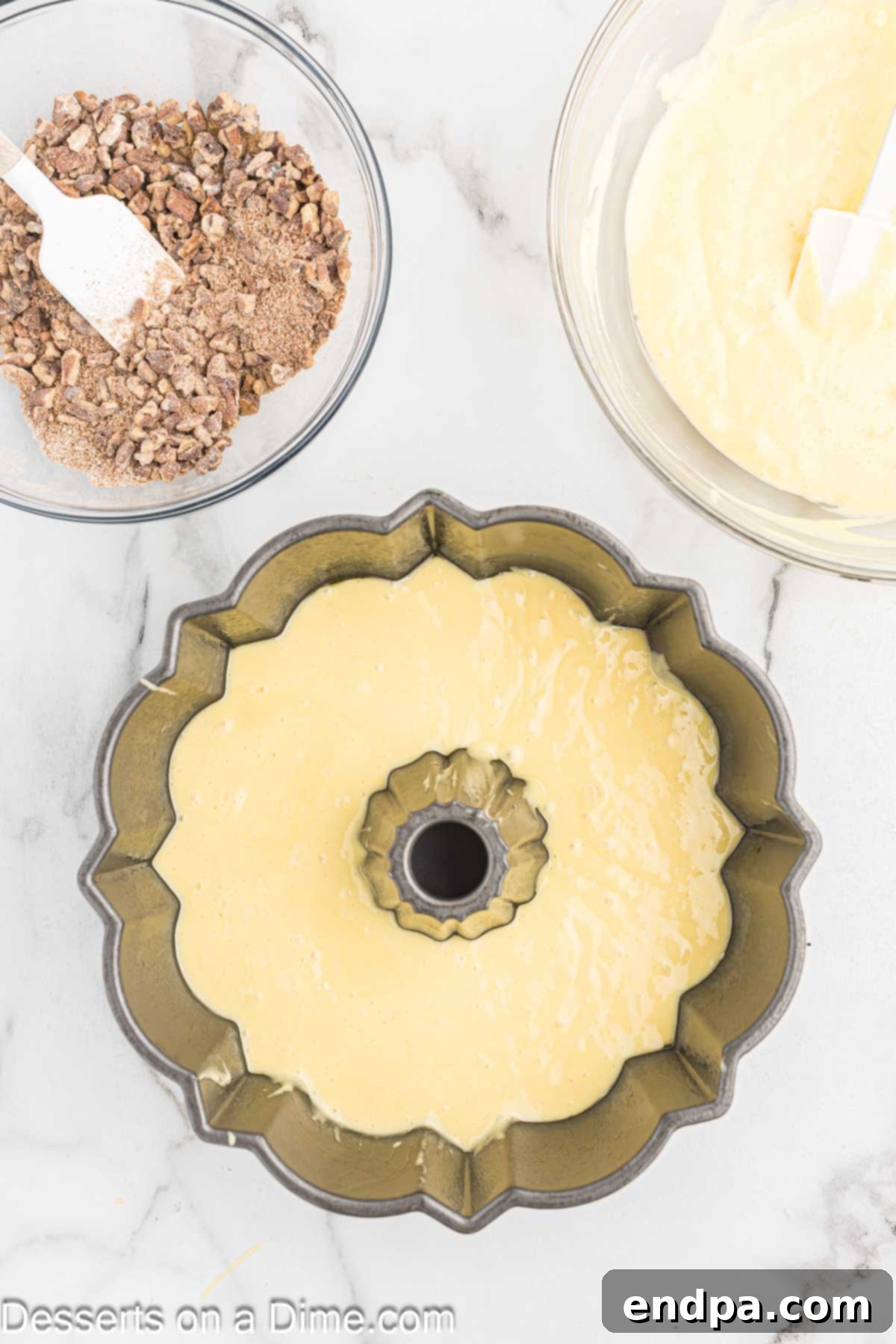 Batter layered in bundt cake pan. A layer of yellow cake batter evenly spread in the bundt pan.