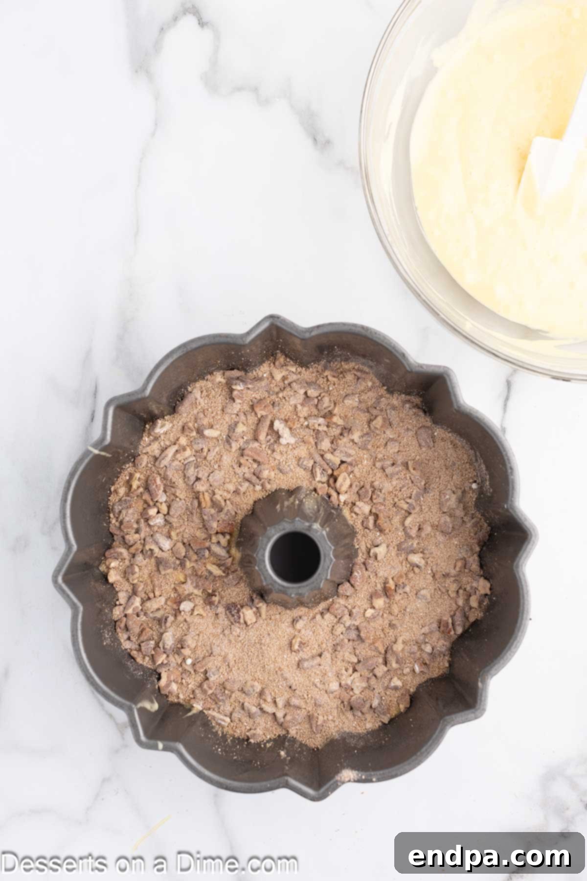 Filling on top of batter in pan. The cinnamon pecan streusel mixture sprinkled over the first layer of cake batter.