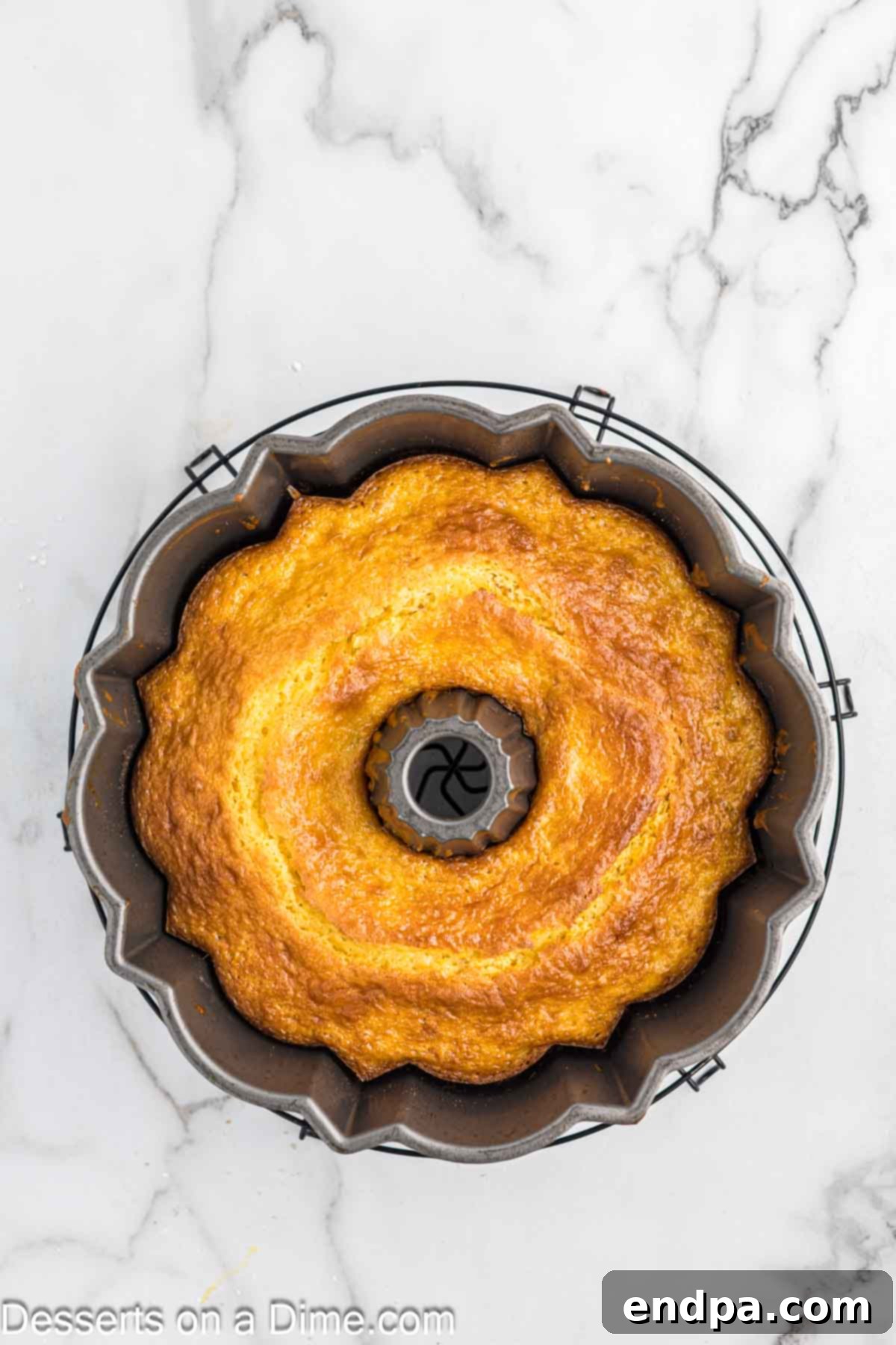 Cake in pan cooling. A freshly baked Sock It To Me Bundt Cake still in its pan, cooling on a wire rack.