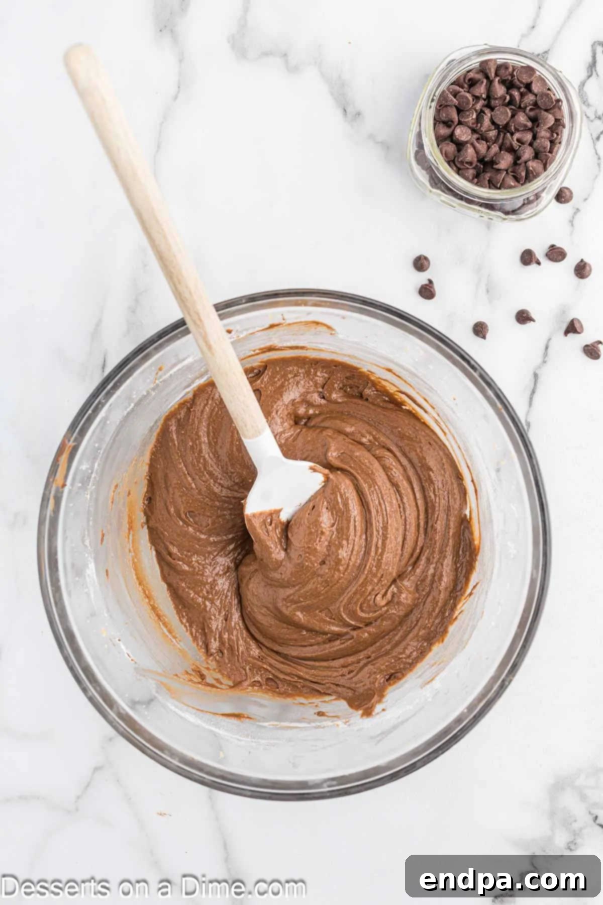 Rich, brown Nutella brownie batter in a mixing bowl, ready for the next ingredients.