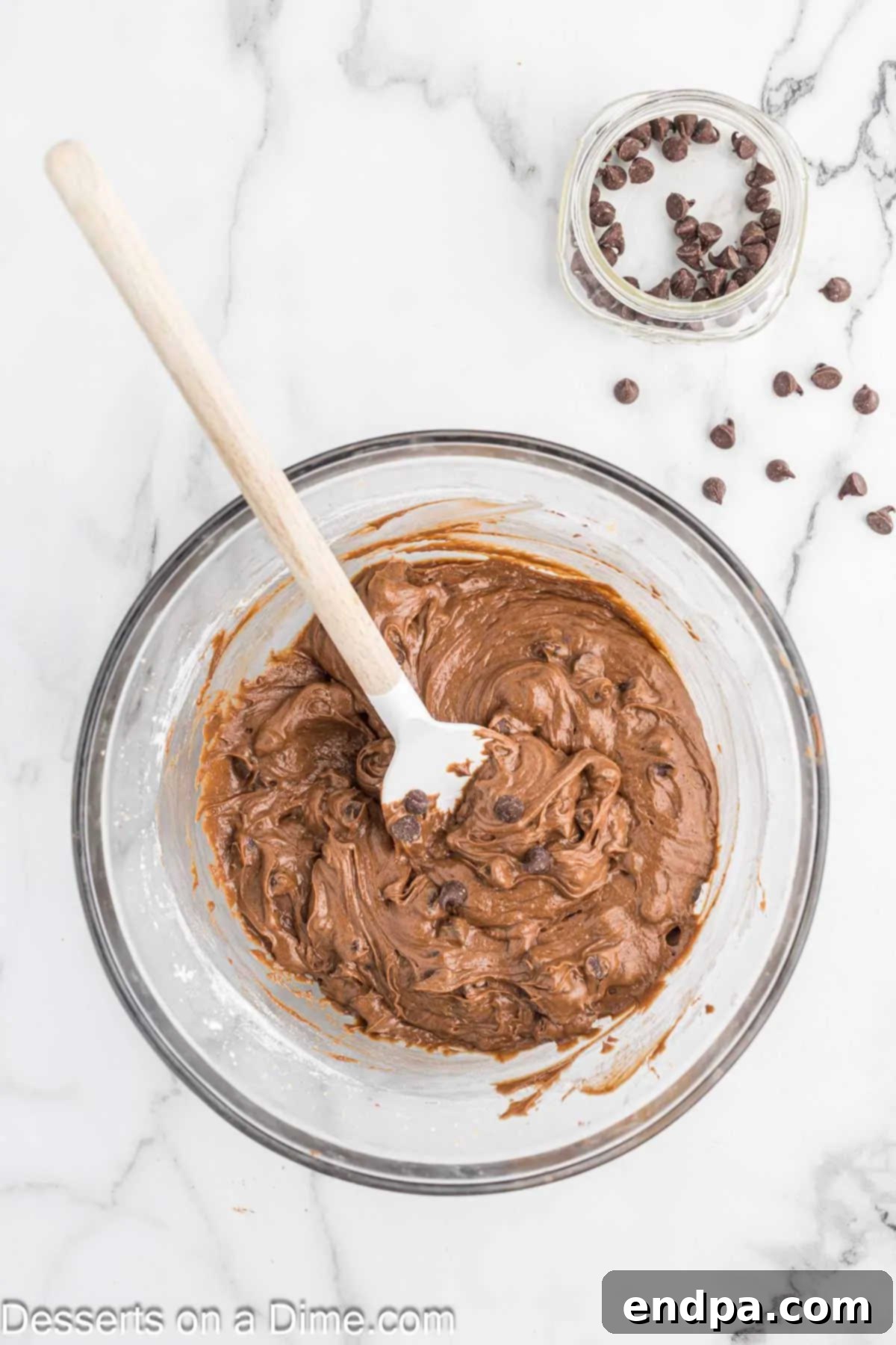Semi-sweet chocolate chips gently folded into the Nutella brownie batter in a bowl.