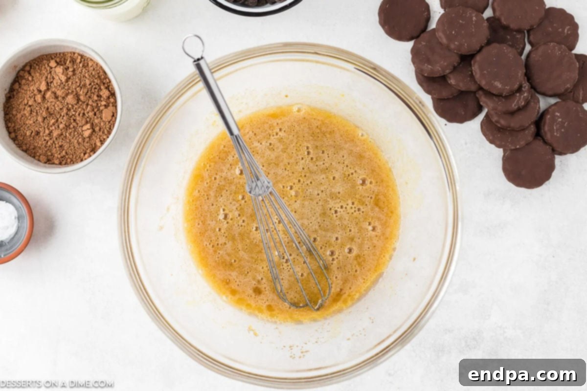 Mixing bowl with sugar, eggs, brown sugar, vanilla extract, and oil combined for cupcake batter.