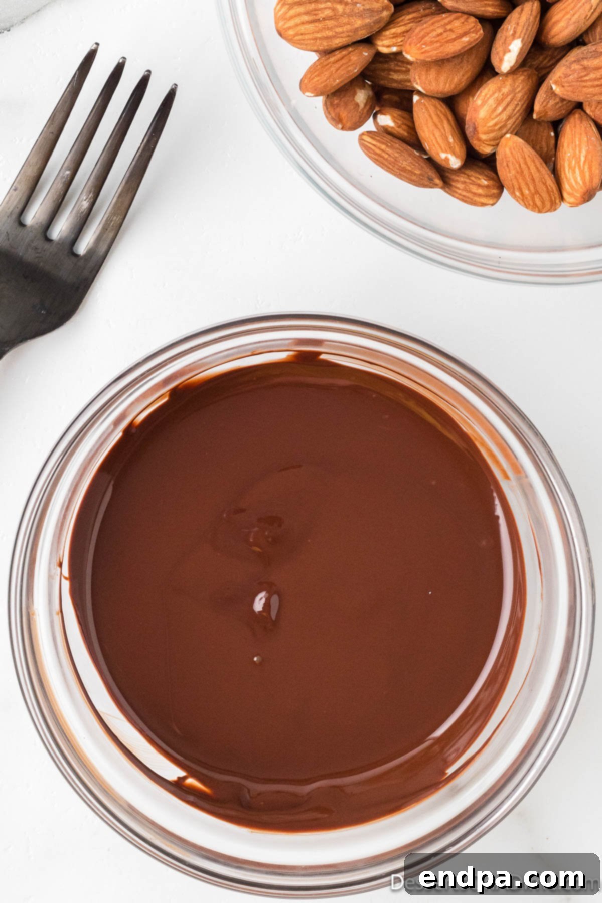 Decadent Dark Chocolate Almonds 4 Smooth, glossy melted dark chocolate in a bowl, stirred to perfection.