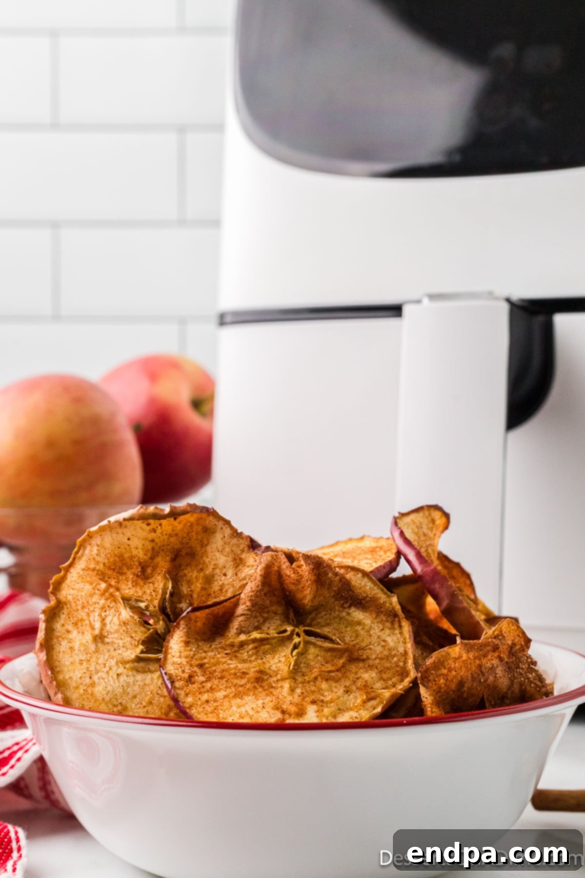 Sweet & Crispy Air Fryer Apple Chips 12 A generous serving of Air Fryer Apple Chips presented in an elegant glass bowl, emphasizing their delicious appeal.