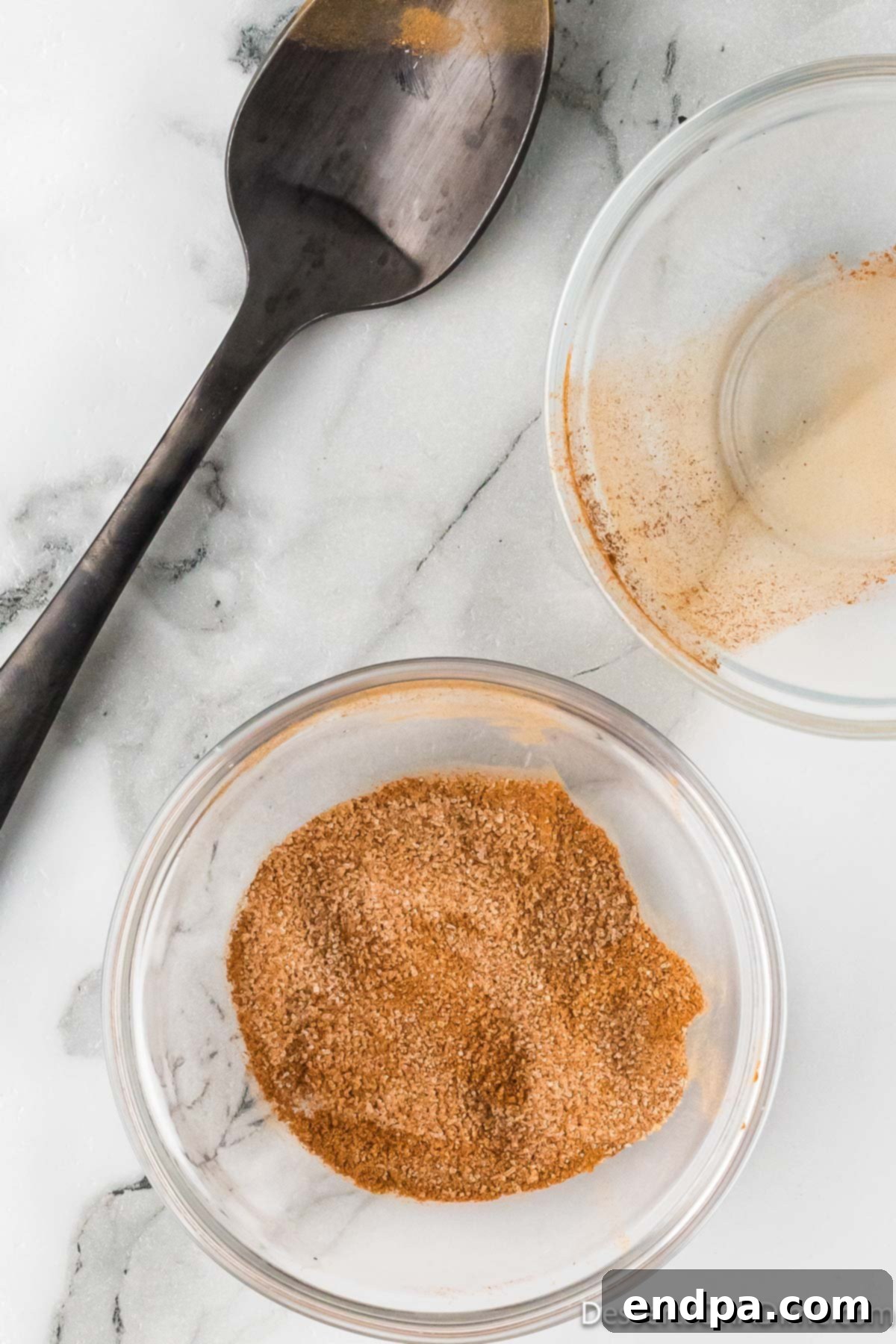 Sweet & Crispy Air Fryer Apple Chips 7 A small glass bowl containing a perfectly mixed blend of granulated sugar and ground cinnamon.