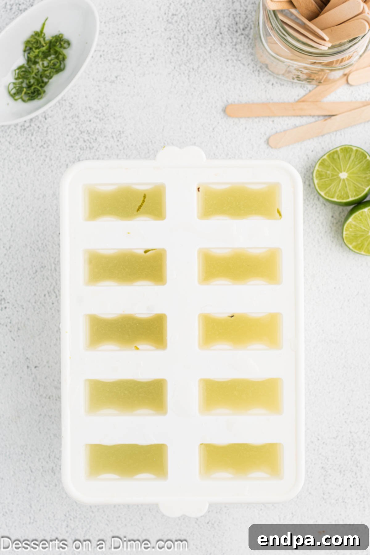 Lime popsicle mixture being poured into popsicle molds.