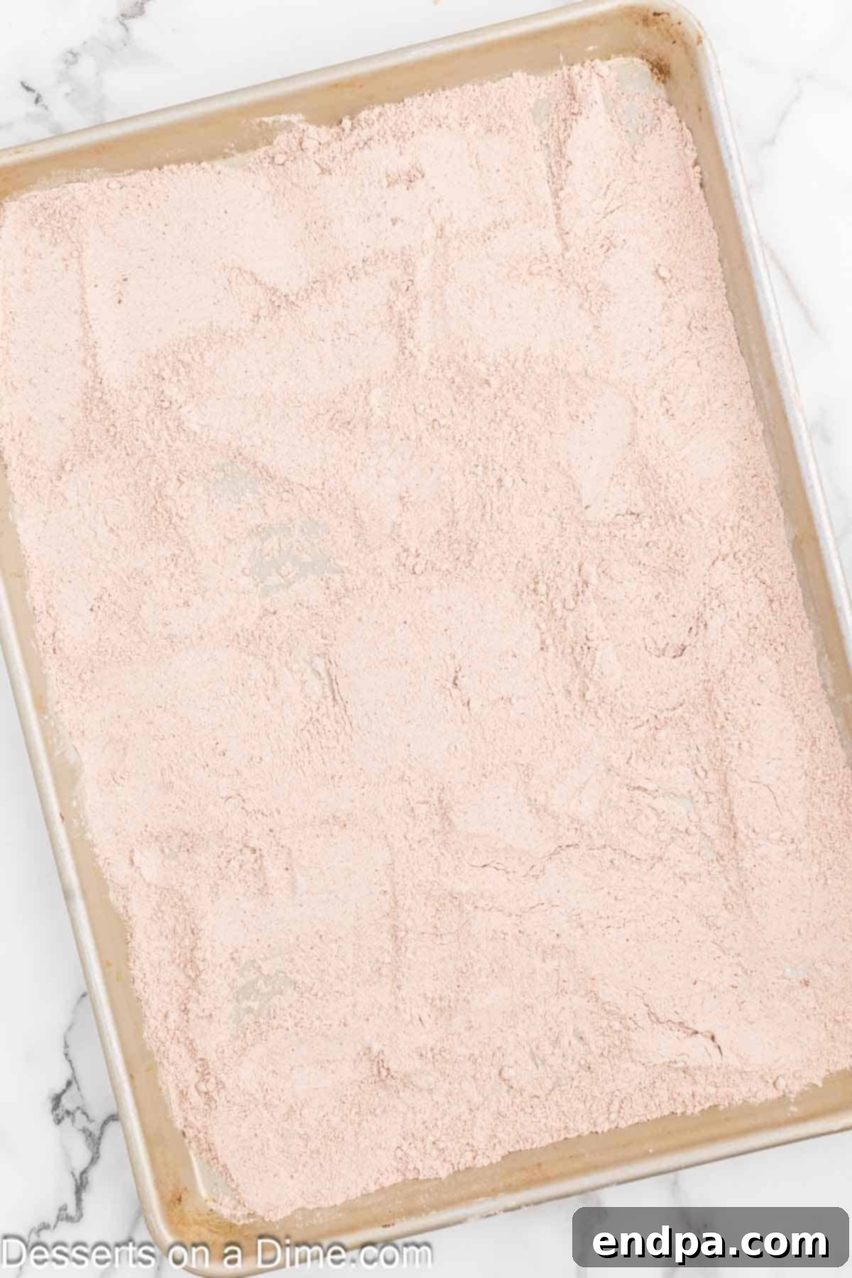 Red Velvet Delight Dip 4 Dry cake mix evenly spread on a baking sheet, ready for the oven to heat-treat the mix.