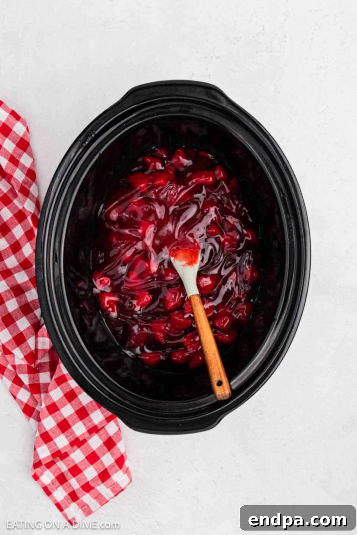 Strawberry pie filling spread on the bottom of a crock pot