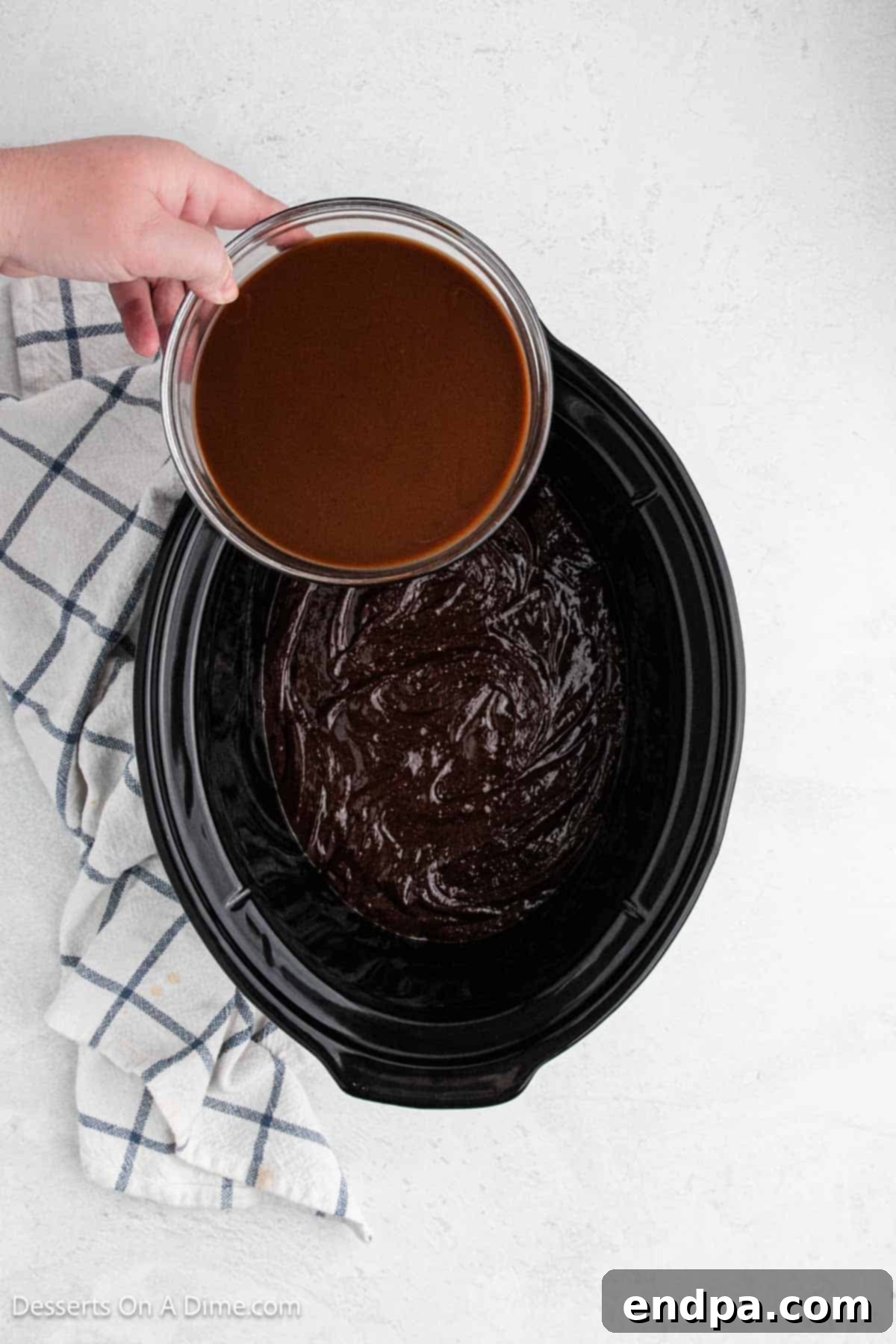 Slow Cooker Chocolate Fudge Brownies 7 Chocolate sauce being poured over batter