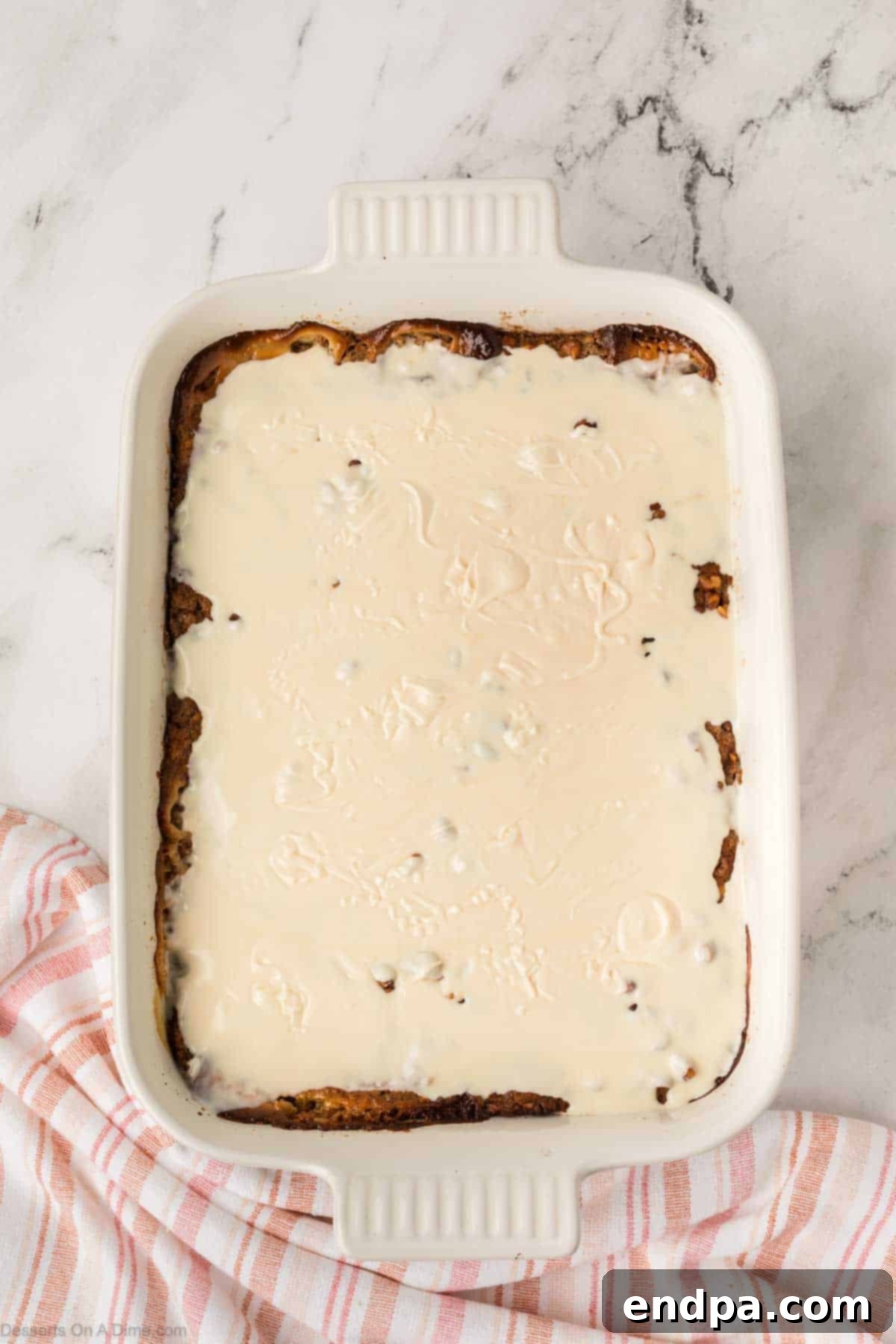 Cream cheese frosting drizzled over the warm cake.