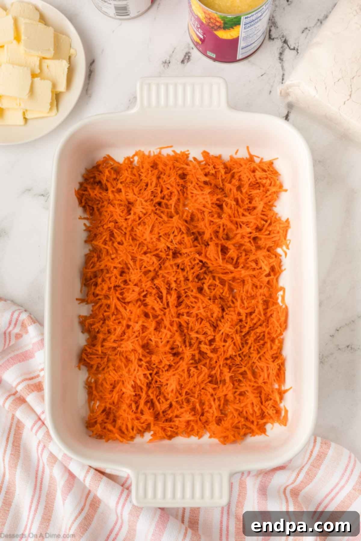 Grated carrots evenly spread in a baking dish.